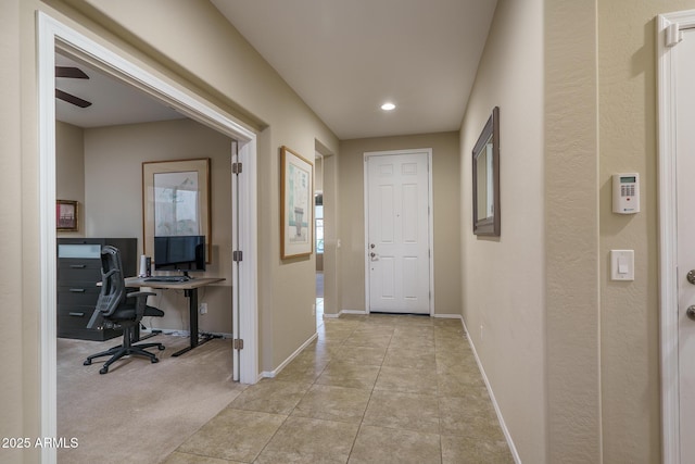 hall with light tile patterned floors and baseboards