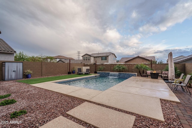 view of pool featuring a fenced in pool, outdoor lounge area, a fenced backyard, a patio area, and an outbuilding