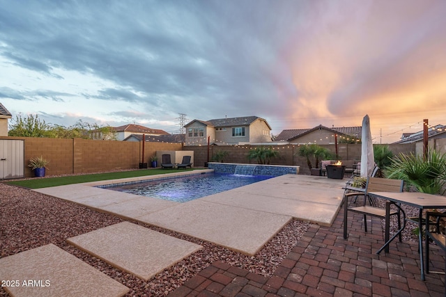 pool at dusk with a fenced in pool, a patio, and a fenced backyard