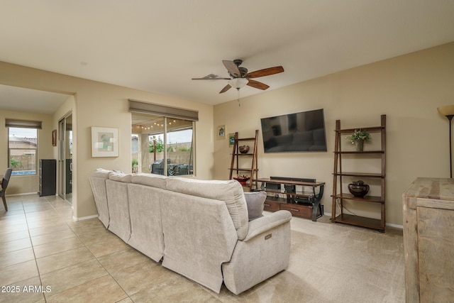 living room with a wealth of natural light, baseboards, ceiling fan, and light tile patterned floors