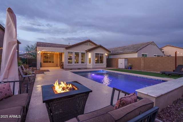 view of swimming pool featuring a patio area, a fenced backyard, a fenced in pool, and an outdoor fire pit