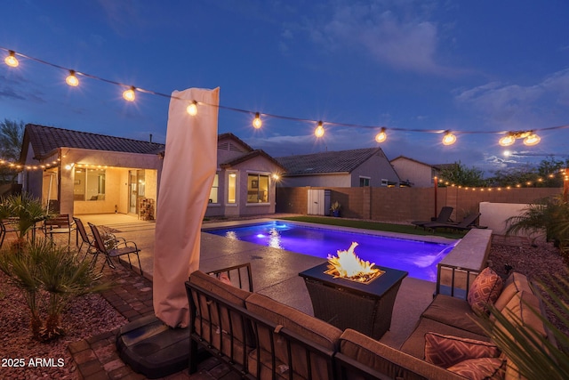 view of swimming pool with a fenced in pool, an outdoor living space with a fire pit, fence private yard, and a patio