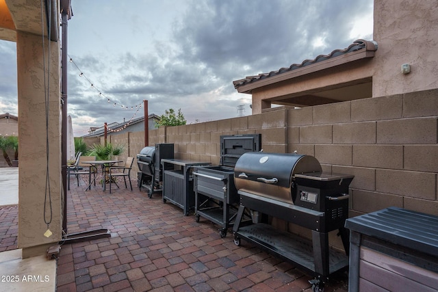 view of patio / terrace featuring outdoor dining space, a grill, and fence