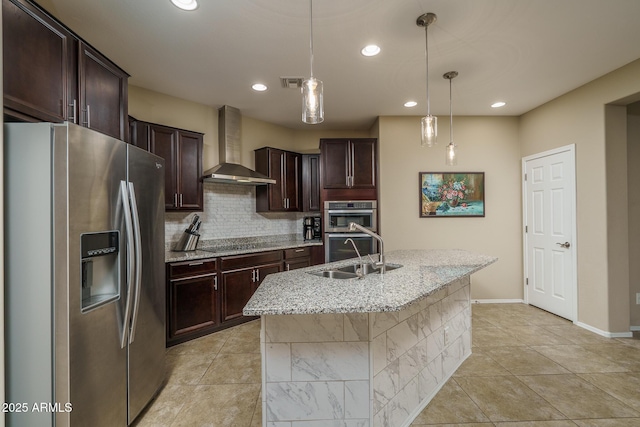 kitchen featuring visible vents, wall chimney range hood, decorative backsplash, appliances with stainless steel finishes, and a sink