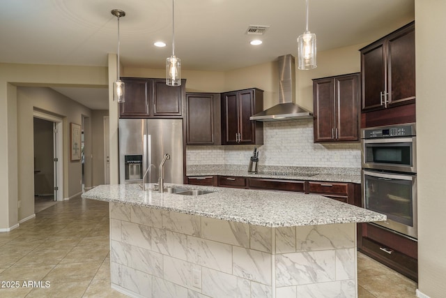 kitchen featuring wall chimney exhaust hood, tasteful backsplash, appliances with stainless steel finishes, and a sink