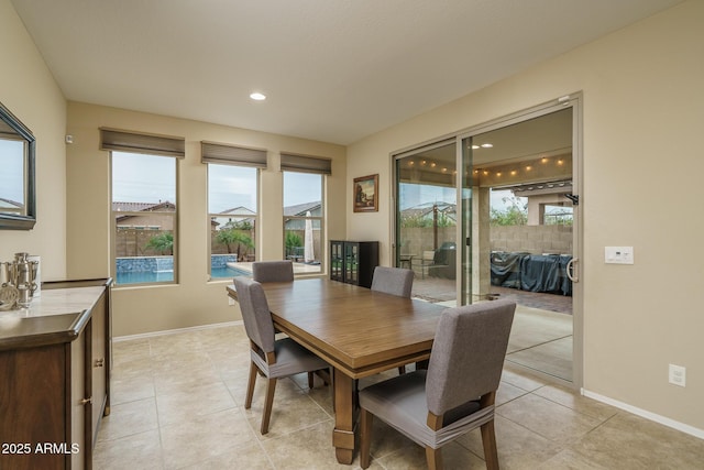 dining room featuring a wealth of natural light, light tile patterned floors, and baseboards