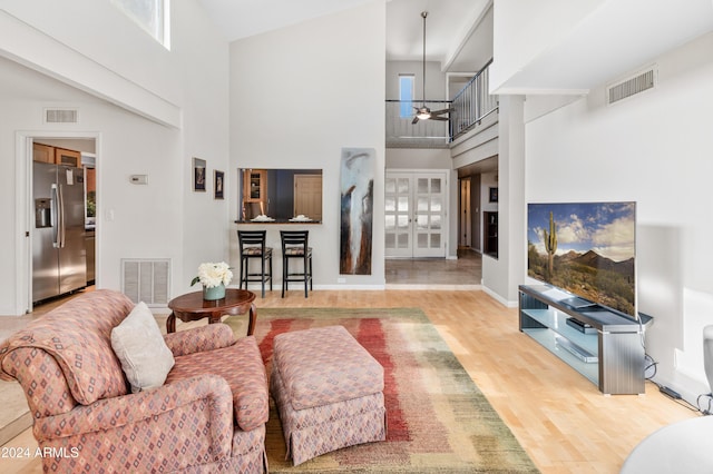 living room with hardwood / wood-style flooring and a towering ceiling