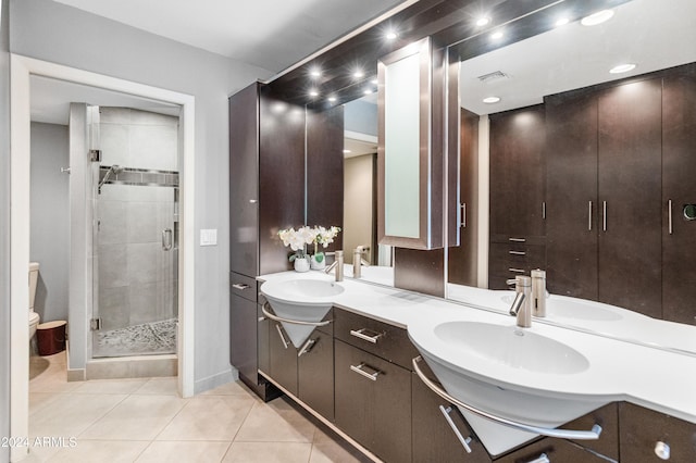 bathroom featuring toilet, vanity, tile patterned floors, and an enclosed shower