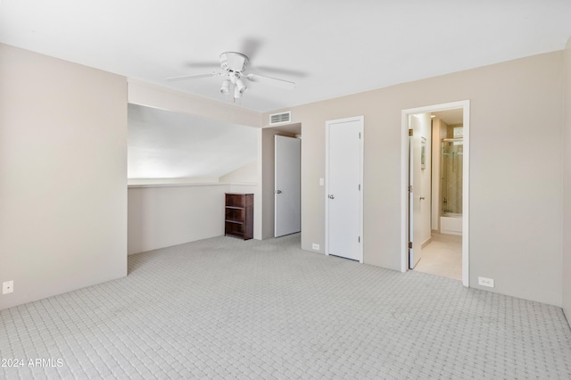 unfurnished bedroom featuring connected bathroom, light colored carpet, ceiling fan, and lofted ceiling