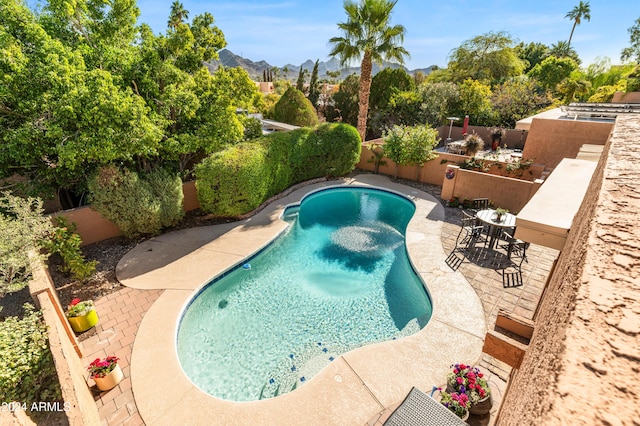 view of swimming pool featuring a patio area and a mountain view