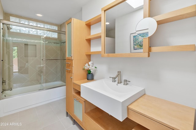 bathroom featuring combined bath / shower with glass door and sink