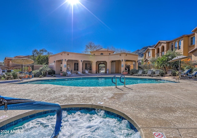 view of swimming pool with a patio area and a community hot tub