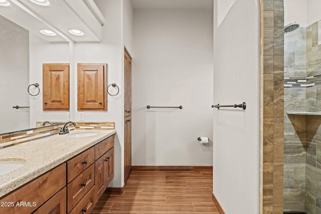 full bathroom featuring a sink, walk in shower, wood tiled floor, and double vanity