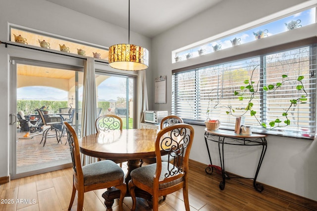 dining room featuring baseboards and light wood-type flooring