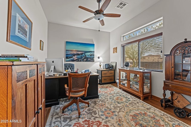 home office with visible vents, baseboards, a ceiling fan, and wood finished floors