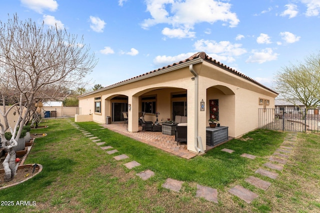 back of house with stucco siding, a lawn, outdoor lounge area, a fenced backyard, and a patio area