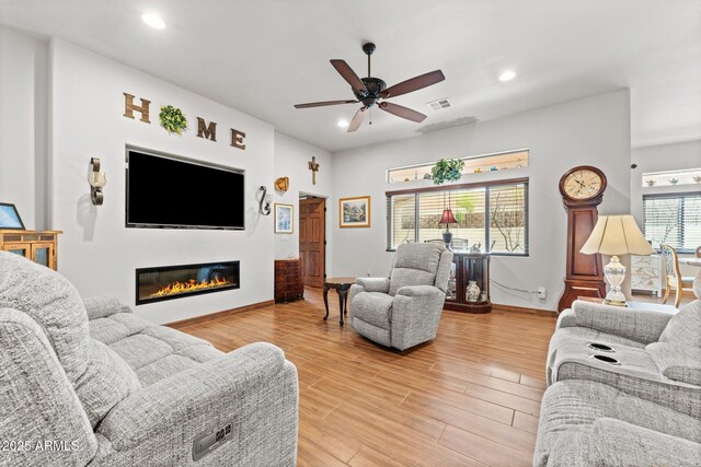 living room with visible vents, ceiling fan, recessed lighting, light wood-style flooring, and a glass covered fireplace