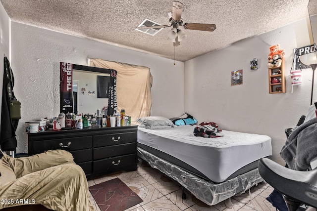 bedroom with a textured wall, a textured ceiling, and a ceiling fan
