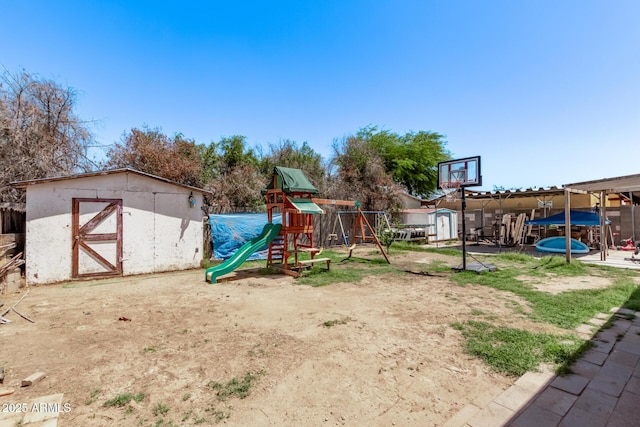 view of playground with a shed and an outbuilding