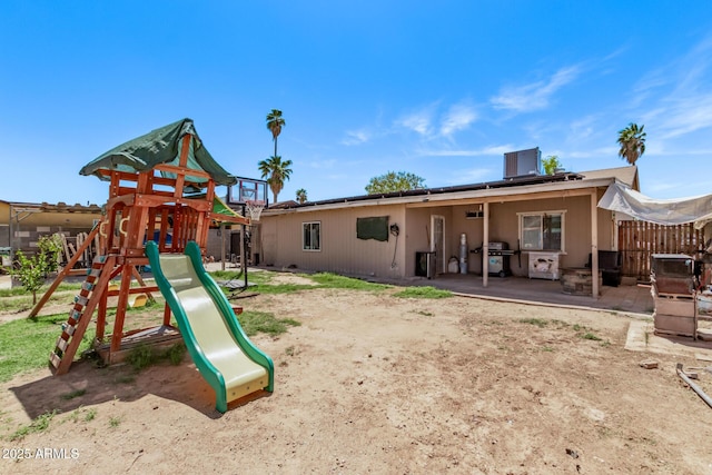 view of jungle gym featuring fence and a patio