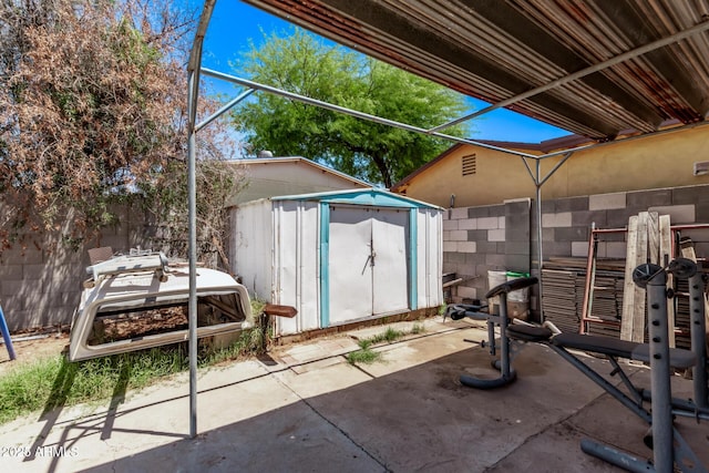 view of patio with a shed, an outdoor structure, and fence