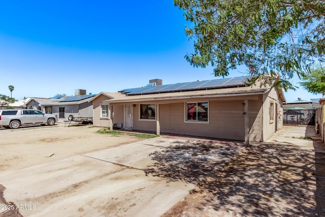 view of front of property featuring solar panels and fence