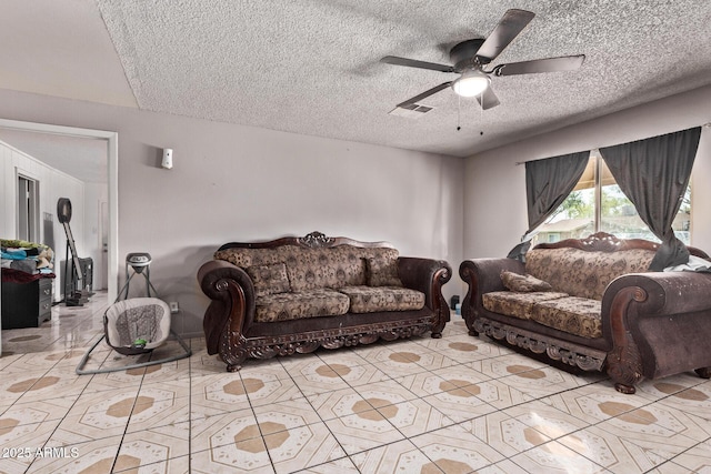 living area featuring a textured ceiling, light tile patterned floors, and ceiling fan