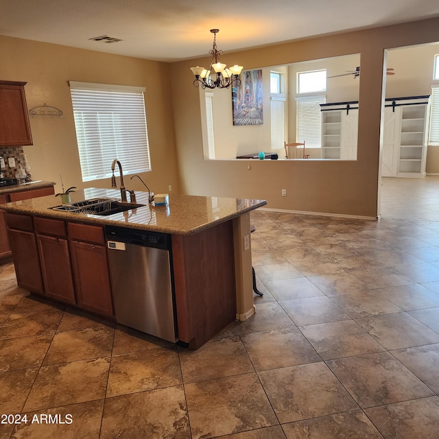 kitchen featuring a center island with sink, sink, stainless steel dishwasher, a barn door, and a notable chandelier