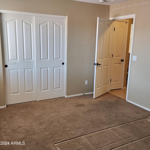 unfurnished bedroom featuring carpet flooring and a closet