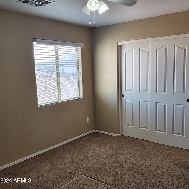 unfurnished bedroom with carpet flooring, ceiling fan, and a closet