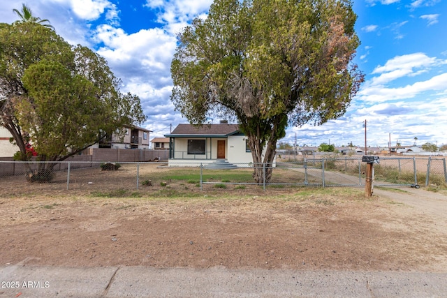 view of yard featuring a fenced front yard, covered porch, and a gate