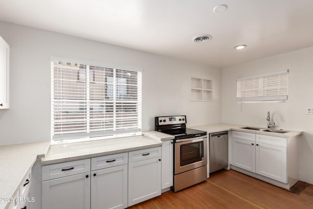 kitchen with white cabinets, stainless steel appliances, and a sink