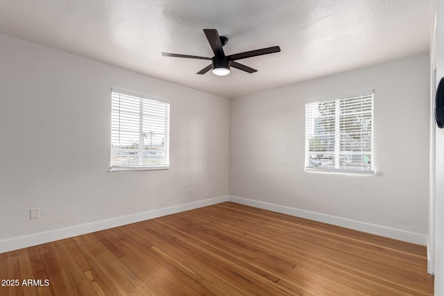 empty room with baseboards, ceiling fan, and light wood finished floors