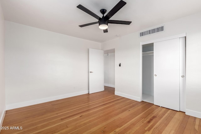 unfurnished bedroom featuring a closet, visible vents, light wood-type flooring, and baseboards