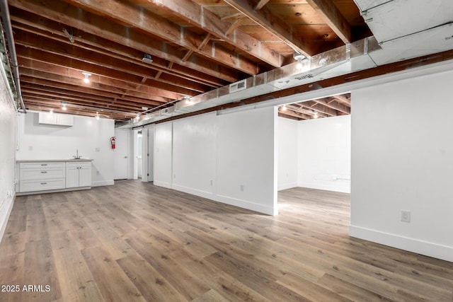 finished basement featuring baseboards and wood finished floors