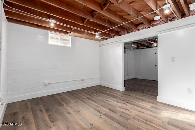 below grade area with baseboards and wood finished floors