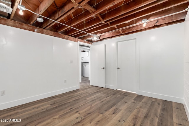 unfinished below grade area with baseboards and wood finished floors