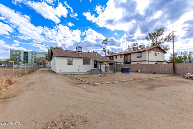 back of house featuring cooling unit, fence private yard, and entry steps