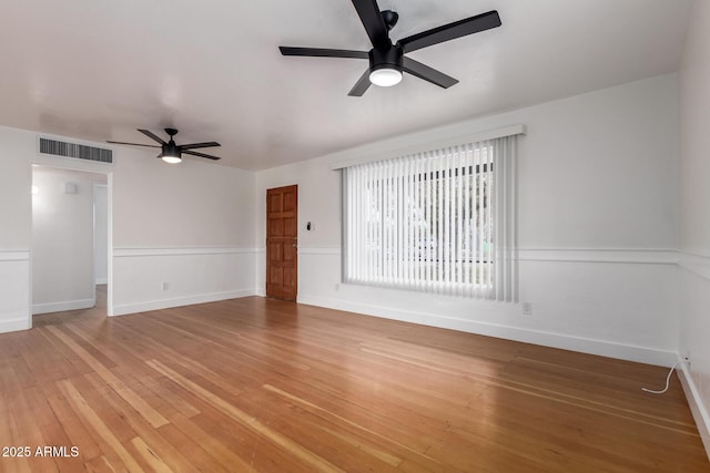 empty room with baseboards, light wood-style floors, visible vents, and ceiling fan