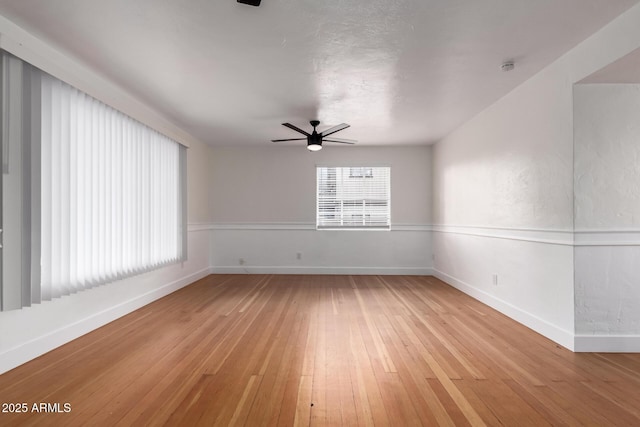 unfurnished room with light wood-type flooring, baseboards, and ceiling fan