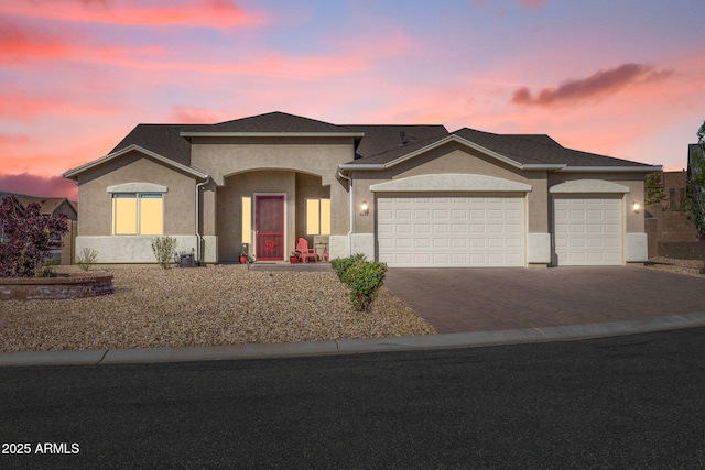 ranch-style home with stucco siding, driveway, and a garage
