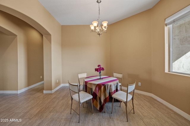 dining room with an inviting chandelier, baseboards, and wood finished floors