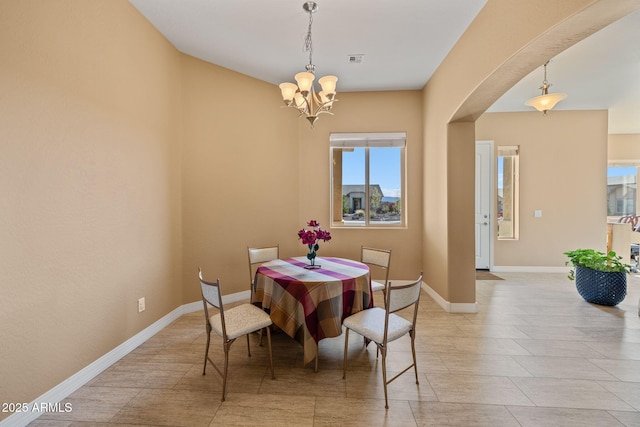 dining area with an inviting chandelier, arched walkways, baseboards, and visible vents