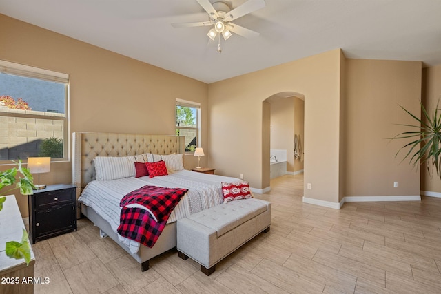 bedroom featuring arched walkways, baseboards, and ceiling fan