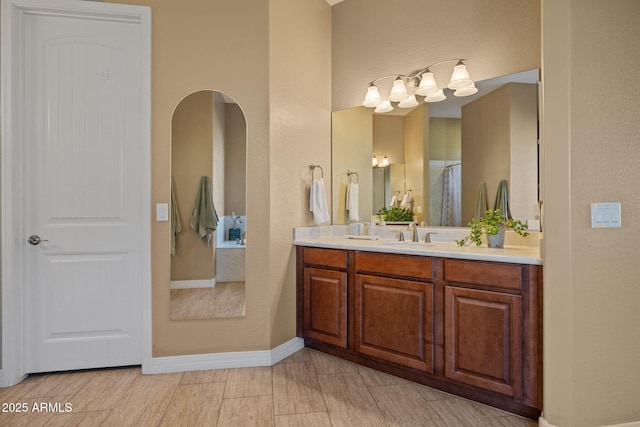 full bath featuring baseboards and vanity