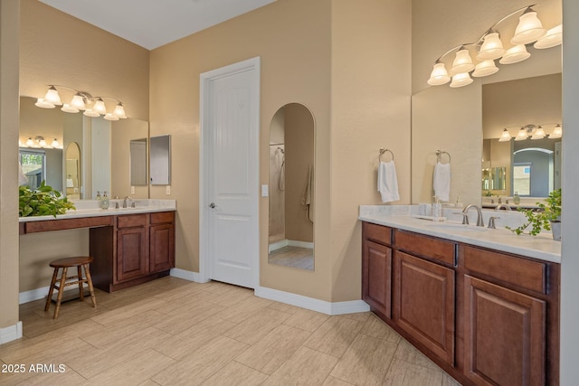 full bathroom with wood finished floors, a sink, baseboards, and two vanities