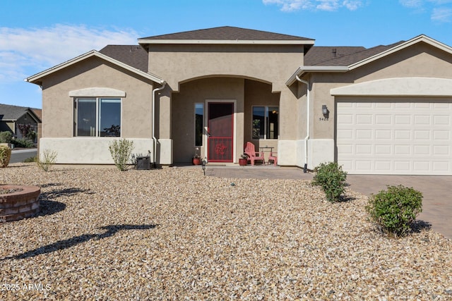 view of front of property featuring a garage, driveway, and stucco siding