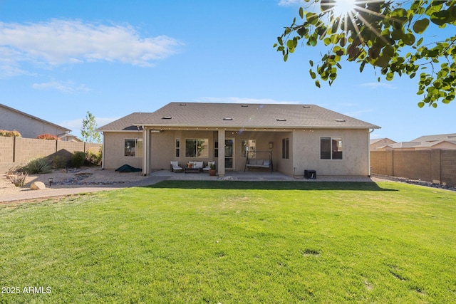 rear view of house with a fenced backyard, a patio area, stucco siding, and a yard