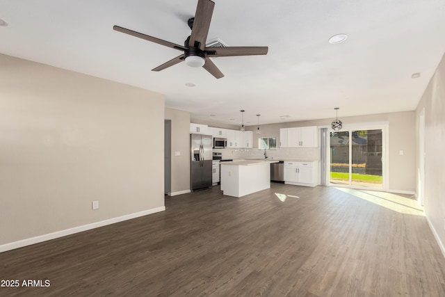 unfurnished living room featuring ceiling fan, sink, and dark hardwood / wood-style floors