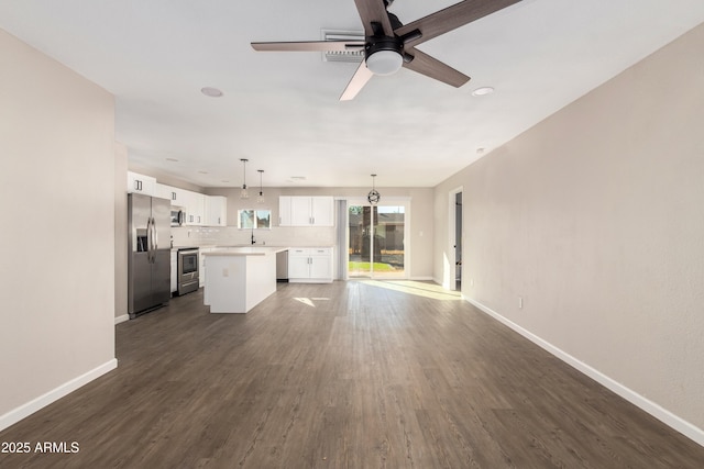 unfurnished living room featuring ceiling fan, dark hardwood / wood-style flooring, and sink